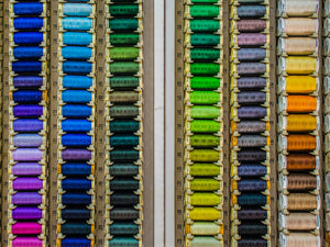 Embroidery thread laid out in an organizational container with like colors. 